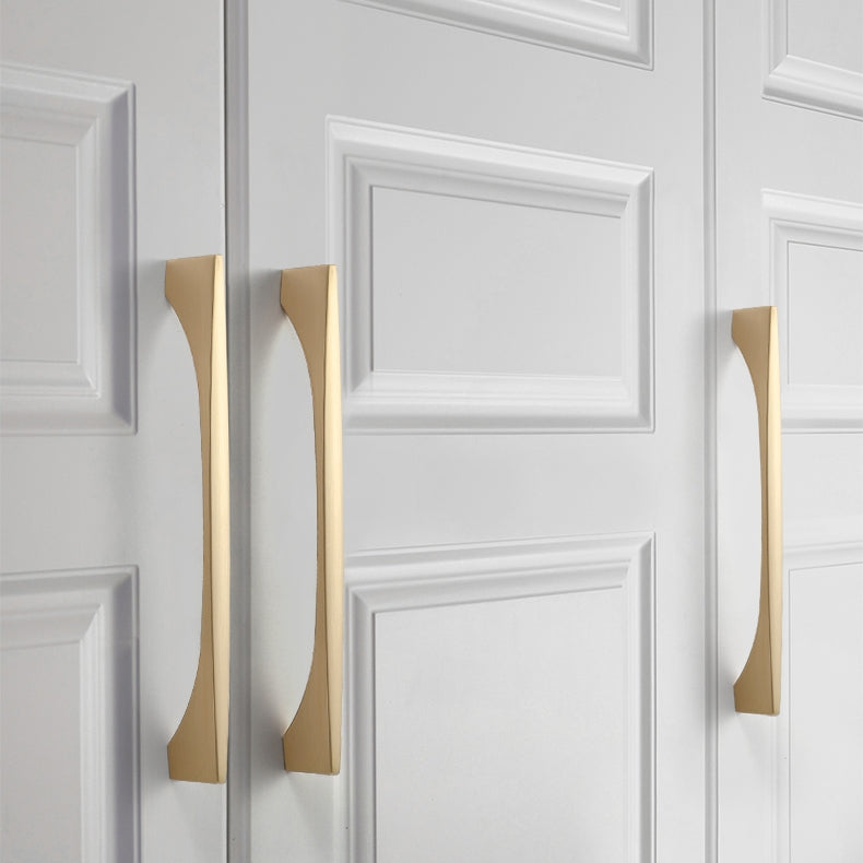 Gold arched aluminum cabinet pull, shown at close range mounted on a finished cabinet front