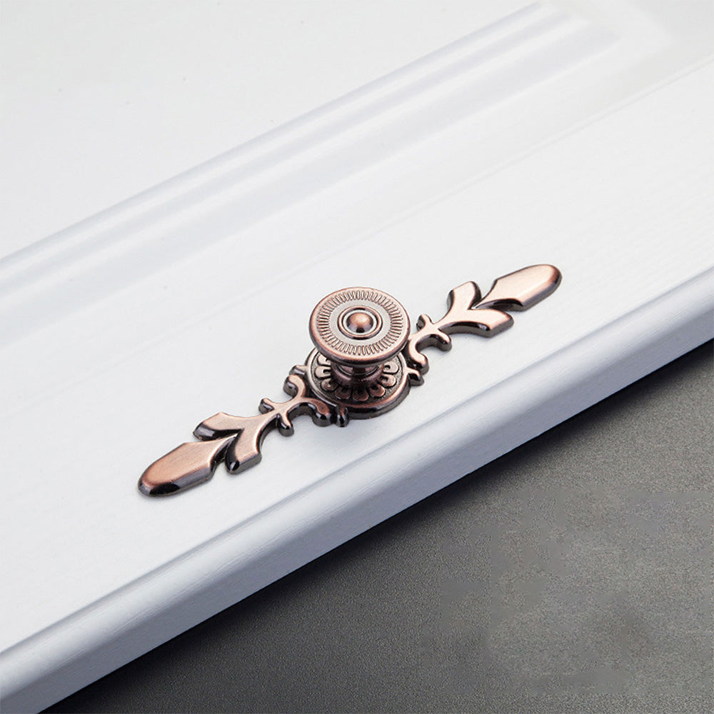 Round cabinet knob with ornate floral backplate, displayed from the side on a clean neutral background