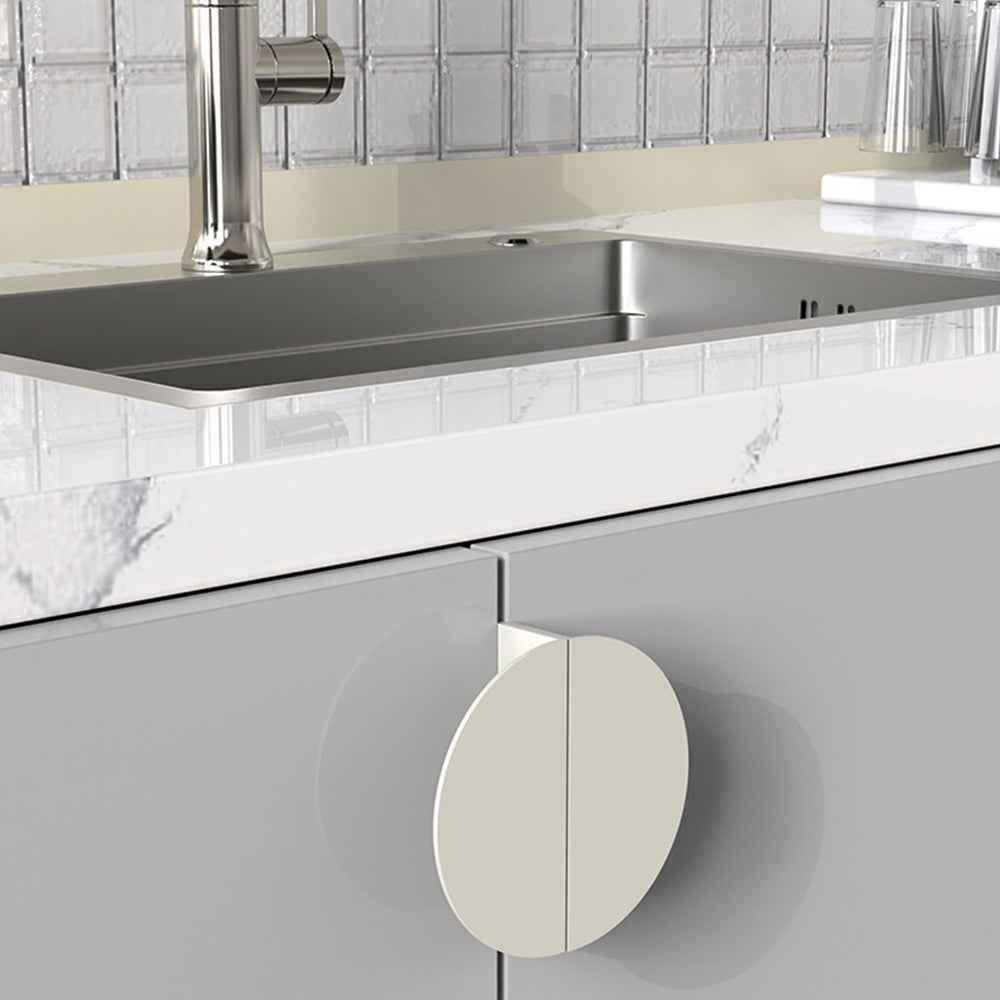 White half-moon cabinet edge pull, shown from one angle in an installed cabinet close-up