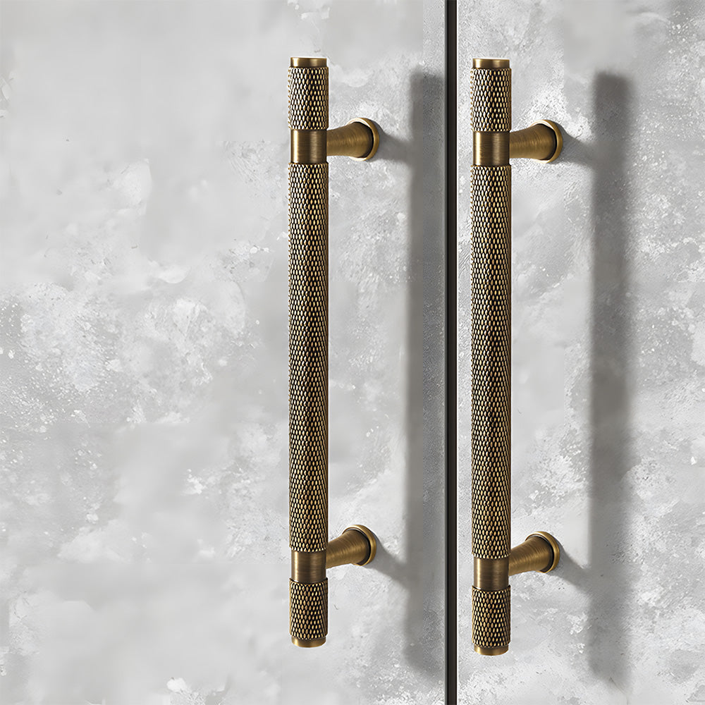Antique bronze knurled brass T-bar cabinet pull, displayed from the side in an installed cabinet close-up