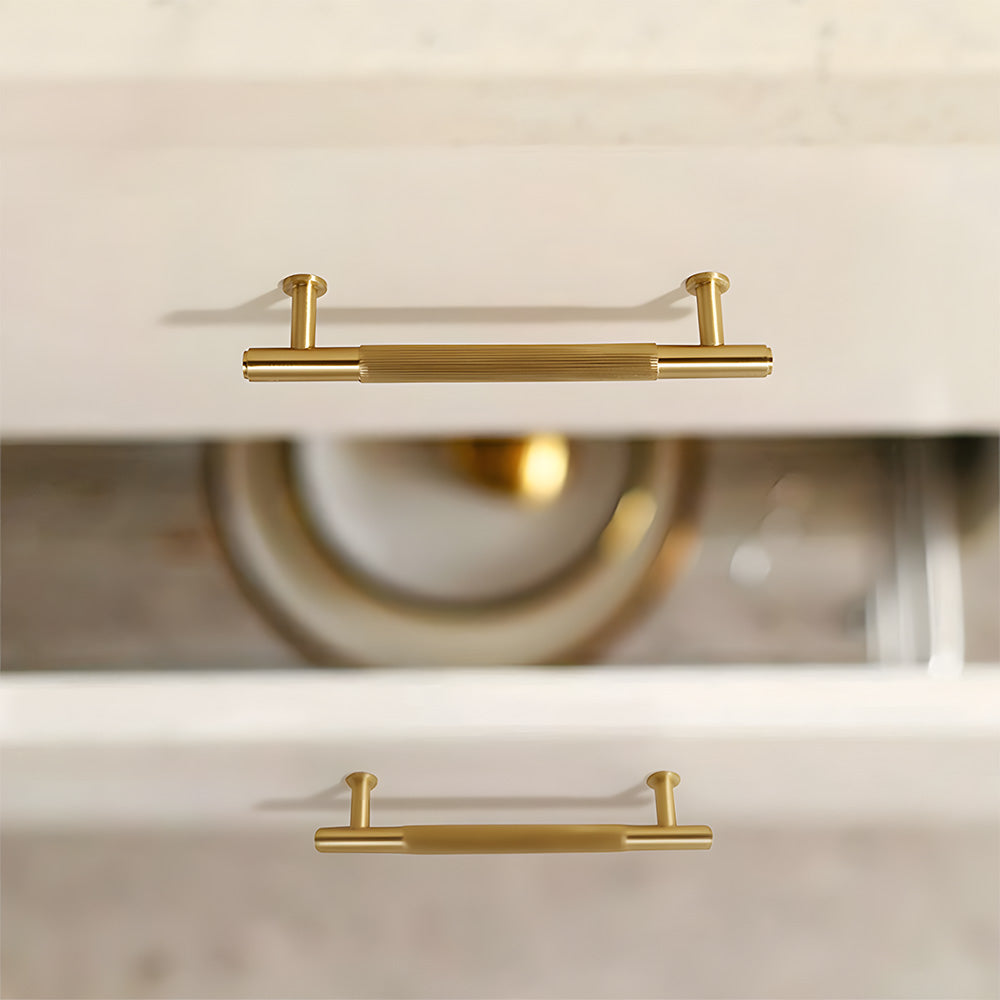 Lined aged-bronze brass T-bar cabinet pull and knob, shown from one angle installed on cabinetry in context