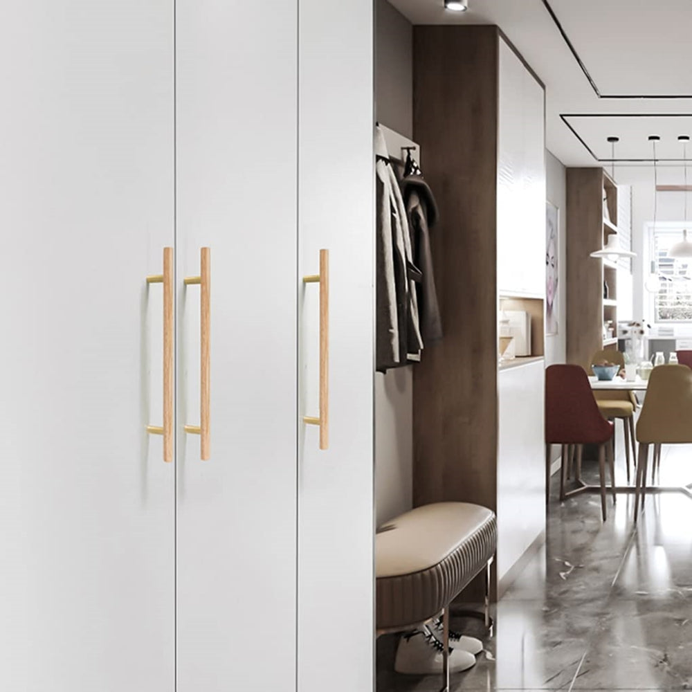 Wood cabinet pull with brass posts in light wood, shown on tall wardrobe doors in a bedroom setting