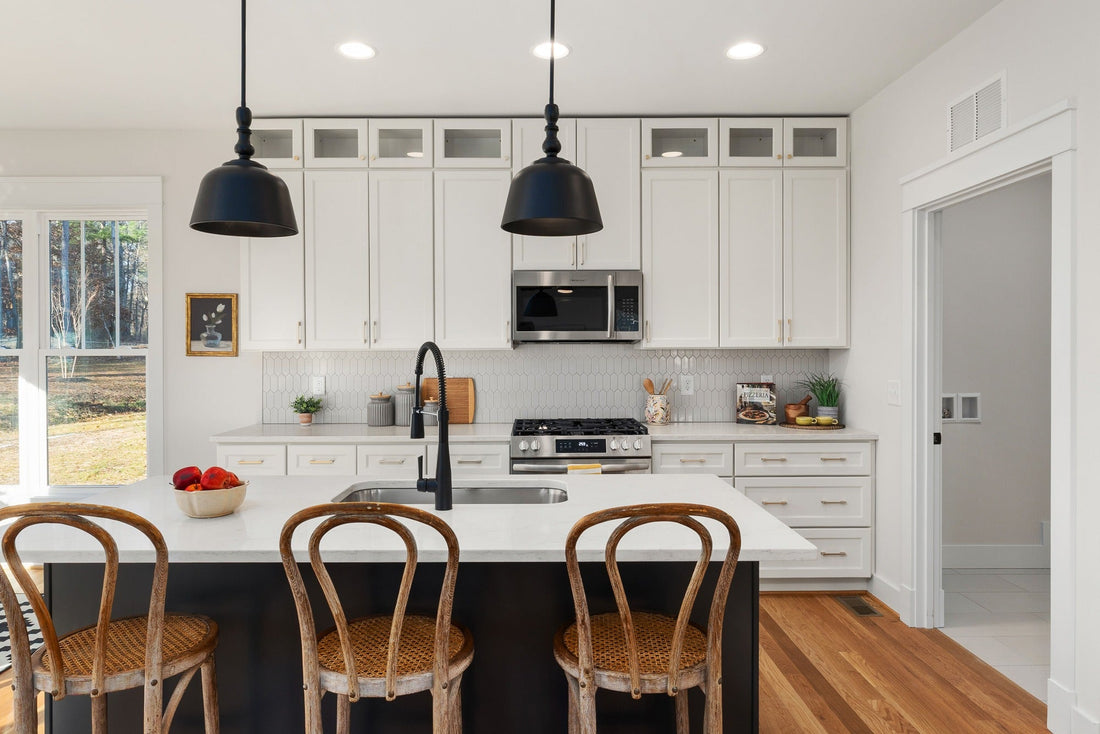 White Shaker kitchen cabinets with brass pulls and black fixtures