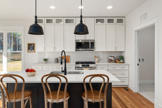 White Shaker kitchen cabinets with brass pulls and black fixtures