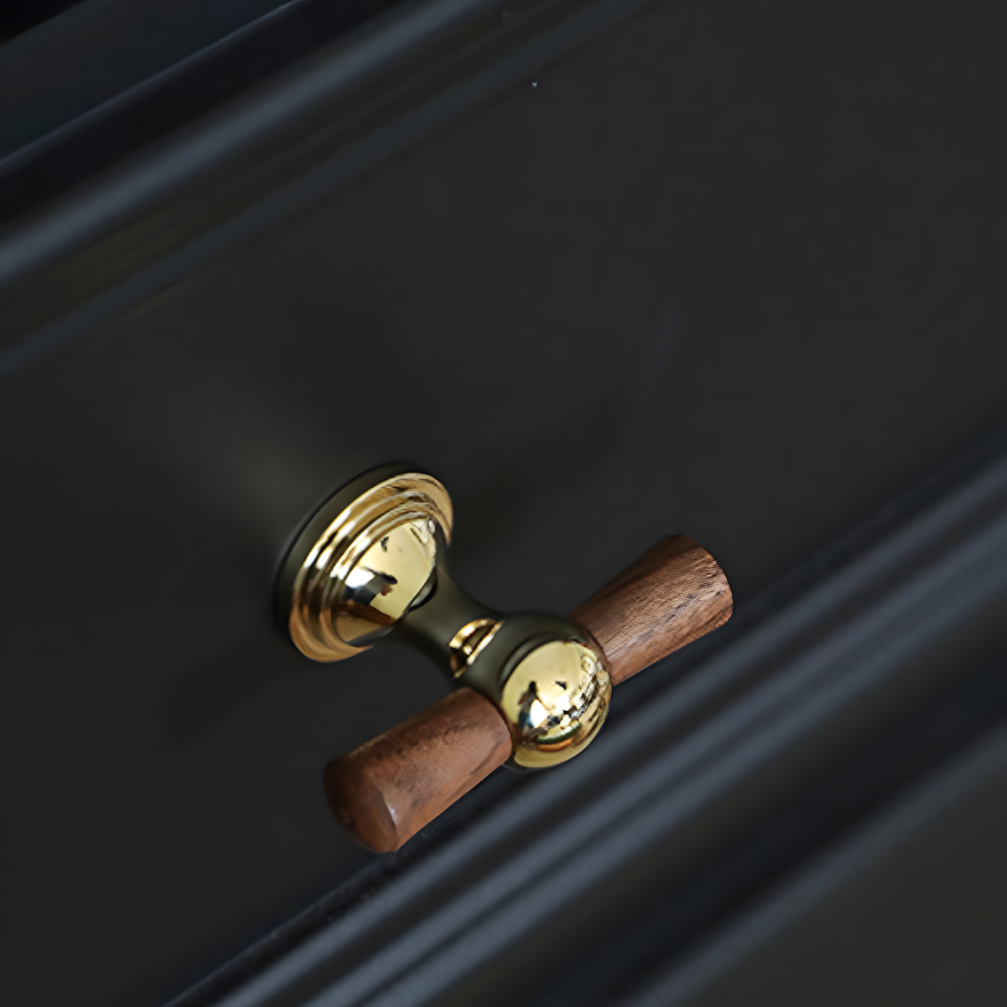Wood T-bar cabinet pull with round metal pedestal mounts, shown clearly in an installed cabinet close-up