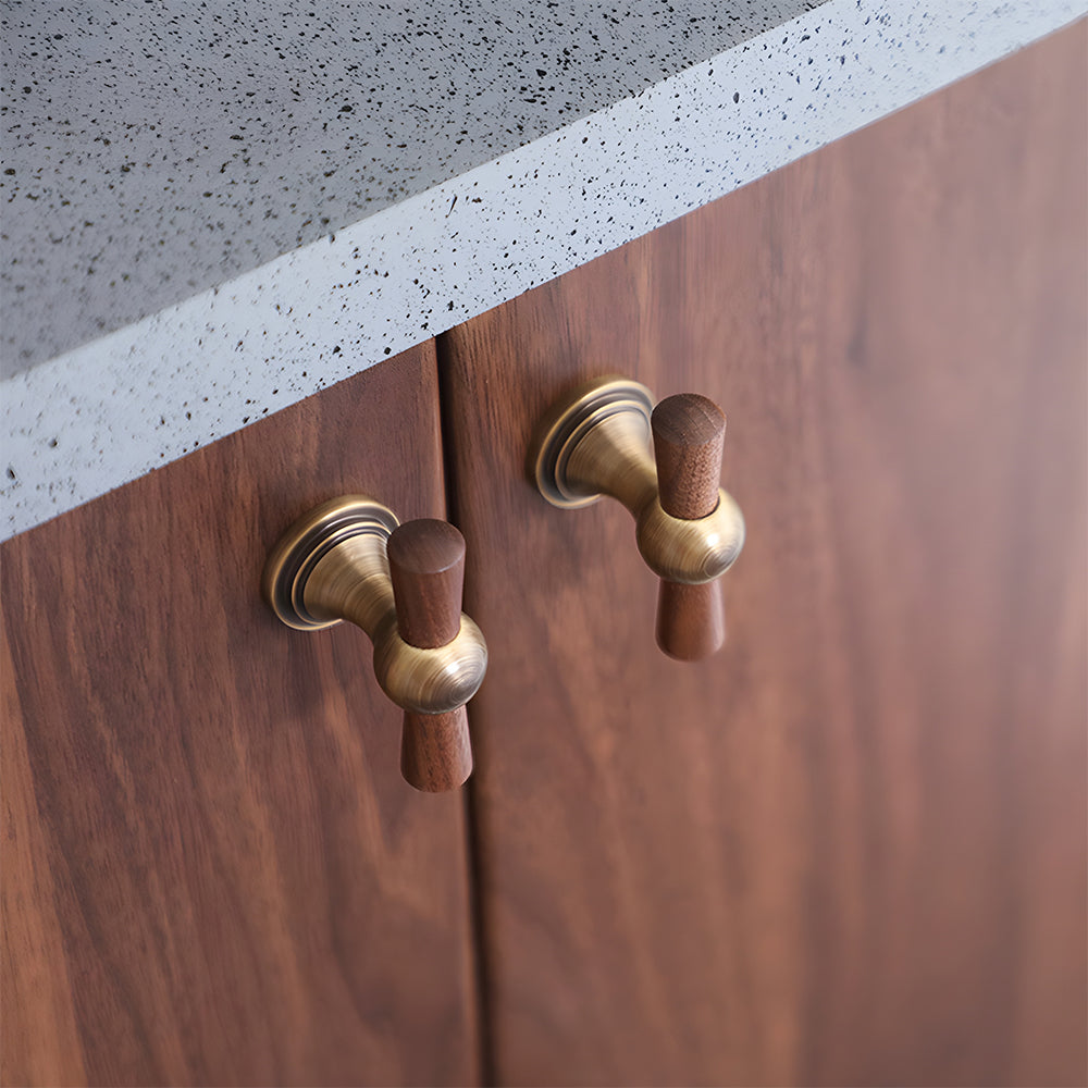 Wood T-bar cabinet pull with round metal pedestal mounts, shown in a focused view installed on cabinetry in context