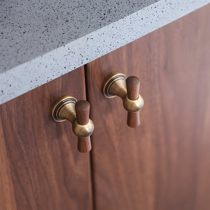 Wood T-bar cabinet pull with round metal pedestal mounts, shown in a focused view installed on cabinetry in context