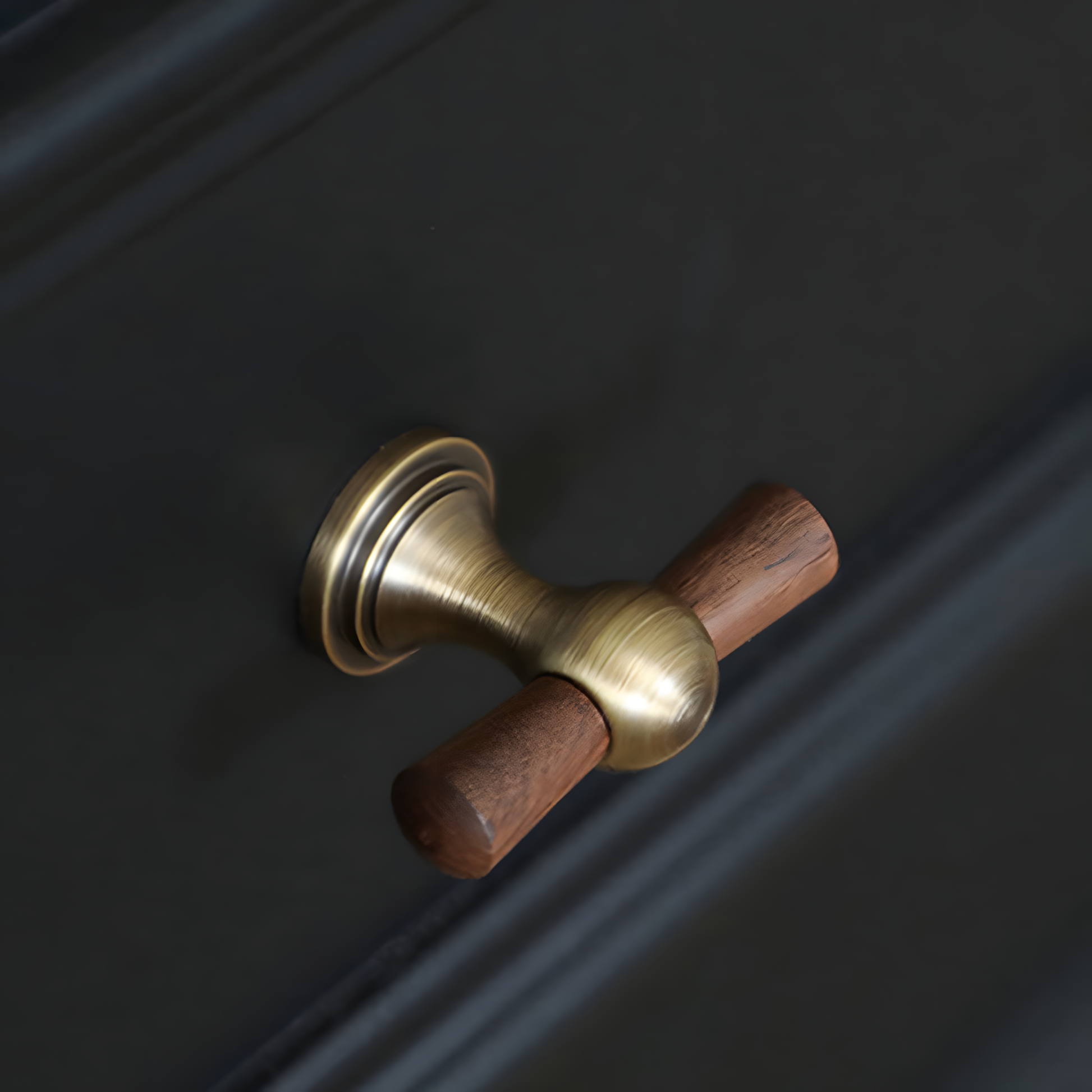Wood T-bar cabinet pull with round metal pedestal mounts, shown from one angle in an installed cabinet close-up
