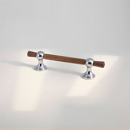 Wood T-bar cabinet pull with round metal pedestal mounts, shown at close range on a clean neutral background