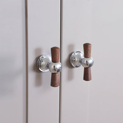 Wood T-bar cabinet pull with round metal pedestal mounts, presented for reference mounted on a finished cabinet front