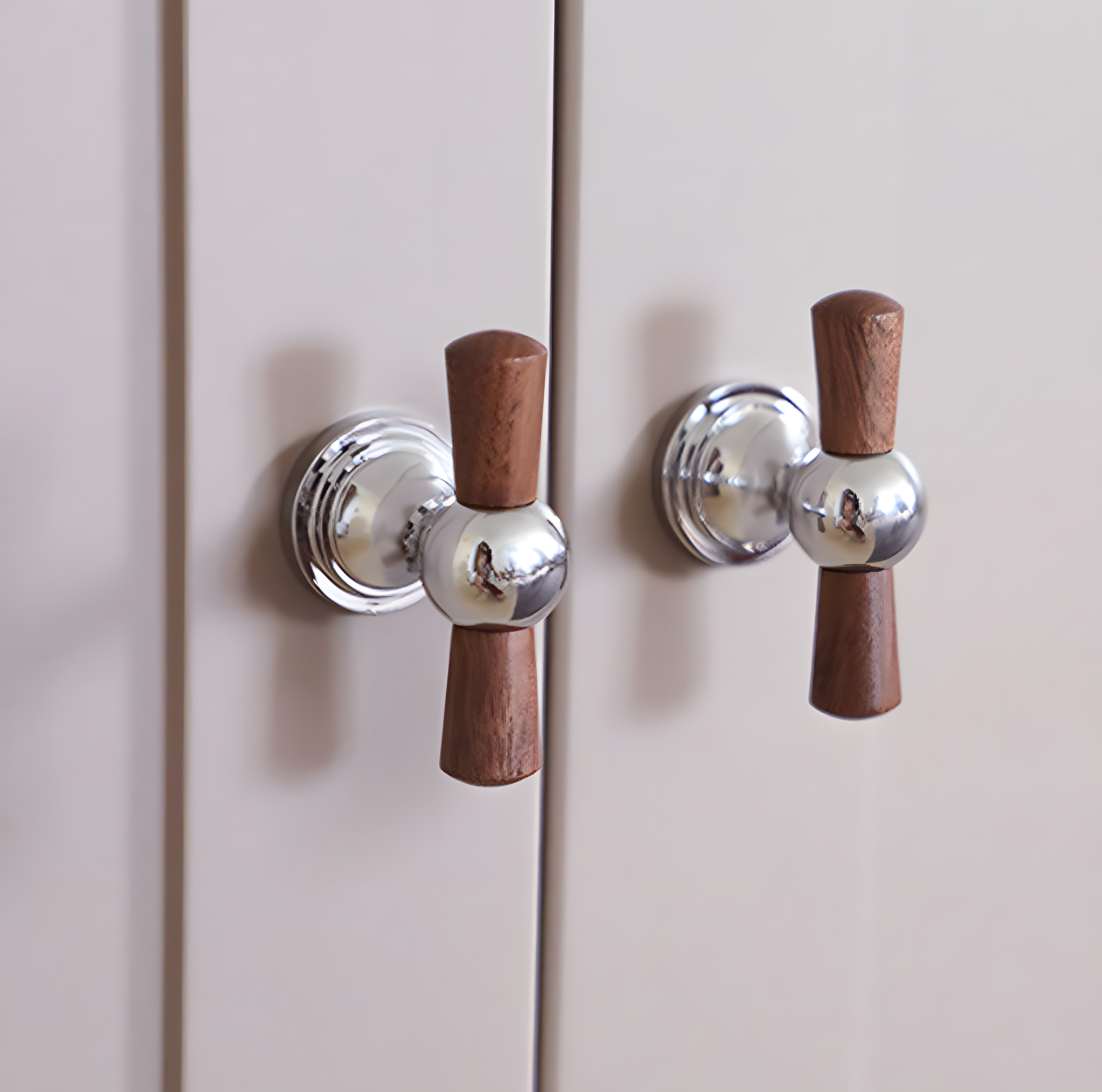 Wood T-bar cabinet pull with round metal pedestal mounts, displayed from the side mounted on a finished cabinet front