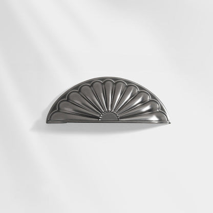 Shell-shaped cabinet cup pull, displayed from the side on a clean neutral background