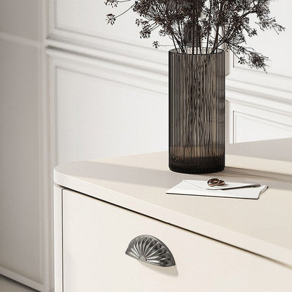 Gray shell-shaped cabinet cup pull, presented in another view installed on cabinetry in context