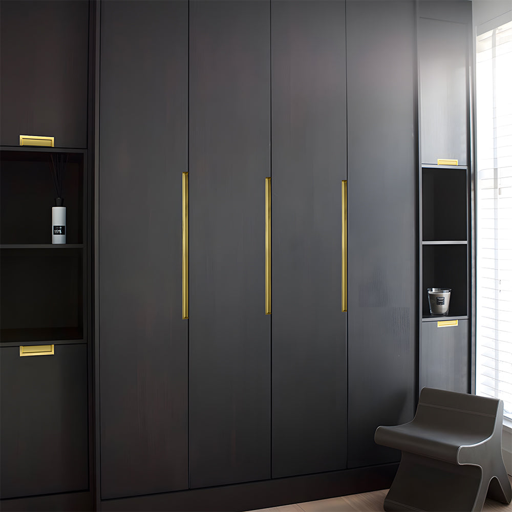 Gold recessed aluminum finger edge pull, shown from one angle installed on cabinetry in context