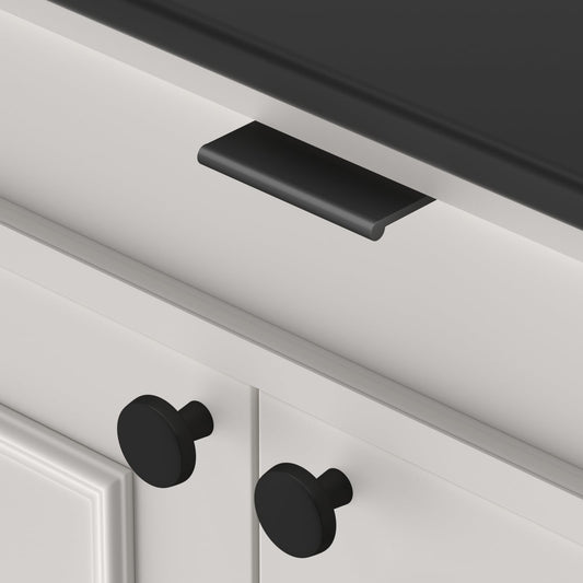 Black square aluminum cabinet edge pull, pictured in one view in an installed cabinet close-up