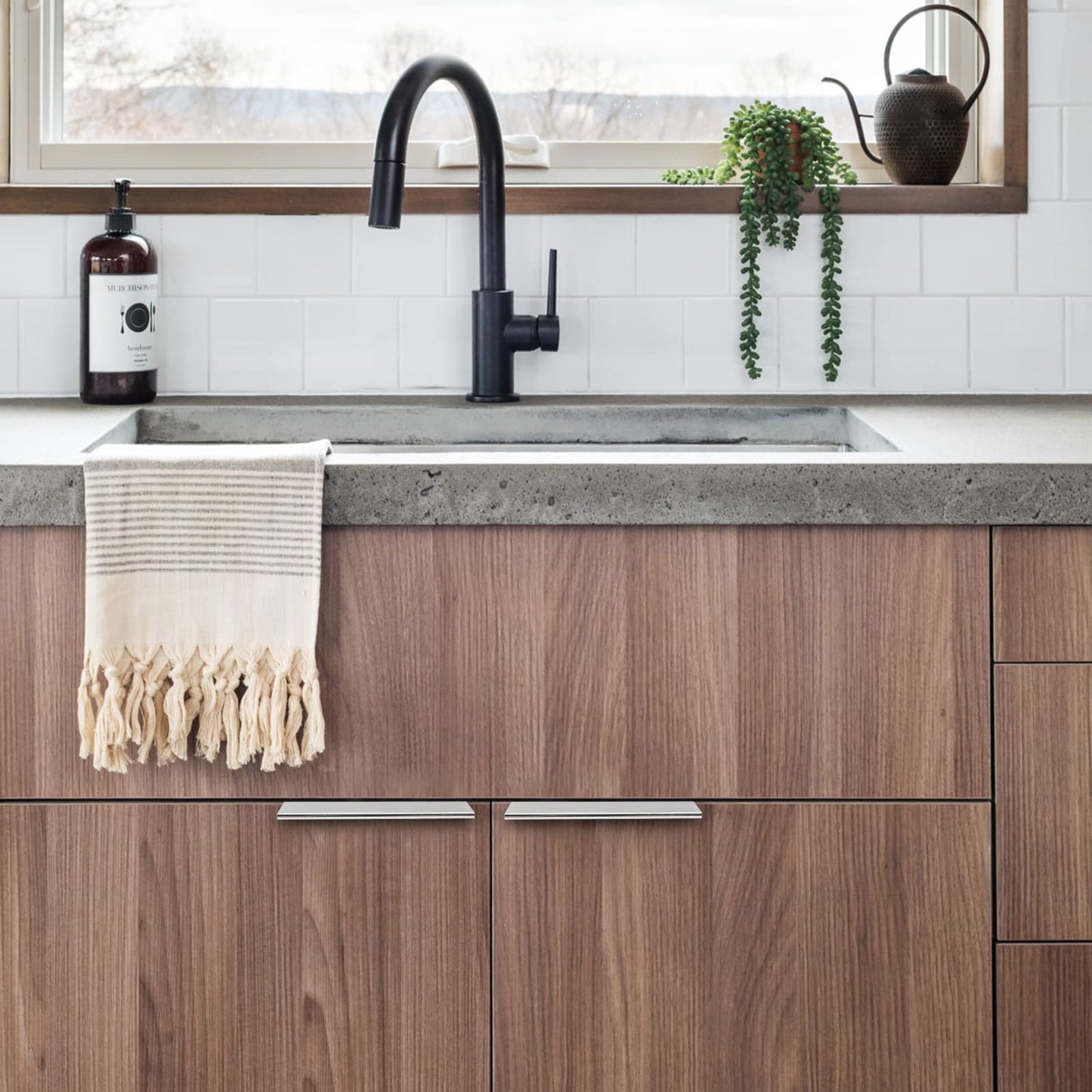 Silver square aluminum cabinet edge pull, shown in a focused view installed on cabinetry in context