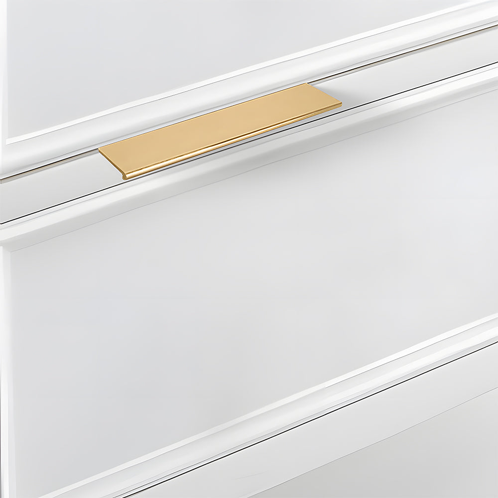 Brushed brass square aluminum cabinet edge pull, shown at close range in an installed cabinet close-up