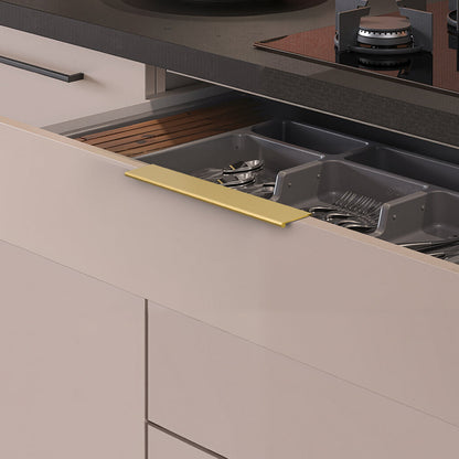 Brushed brass square aluminum cabinet edge pull, shown from one angle with its installed position visible