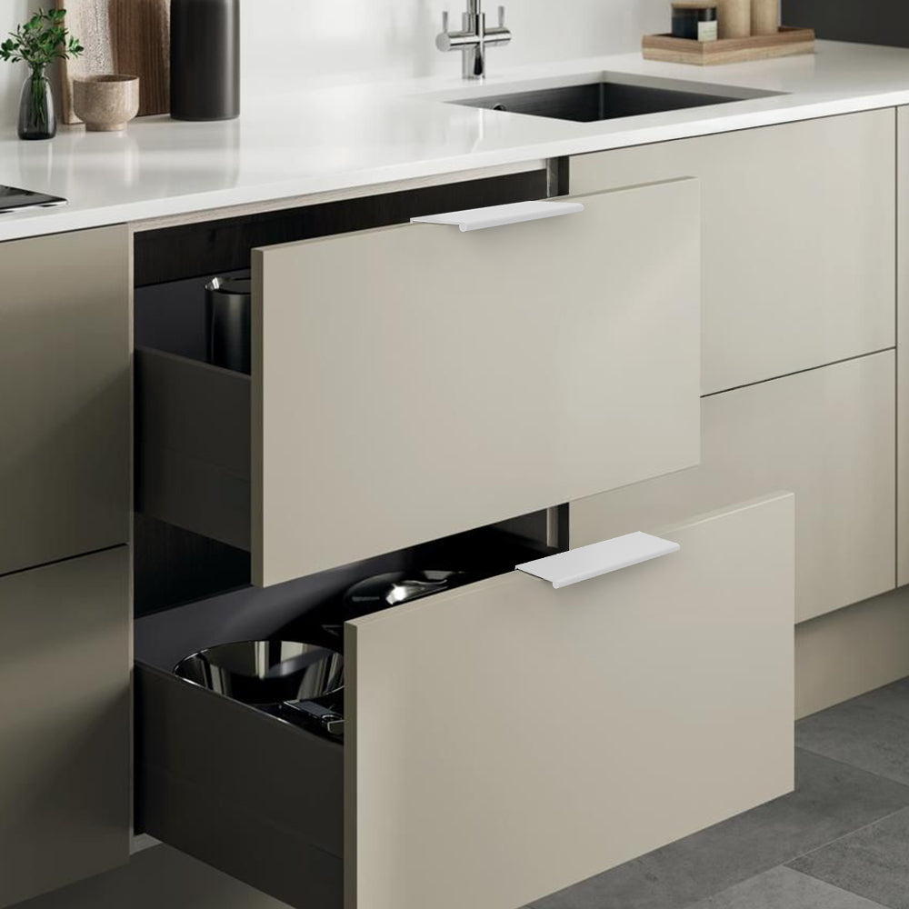 White square aluminum cabinet edge pull, shown at close range with its installed position visible