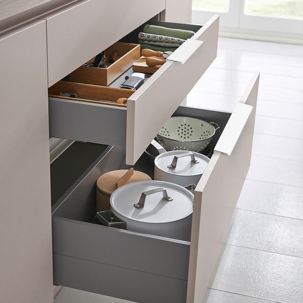 White square aluminum cabinet edge pull, presented in another view with its installed position visible