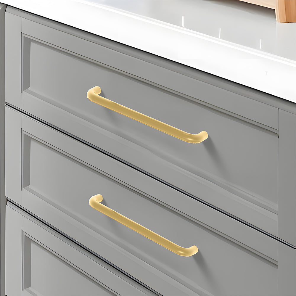 Gold rounded aluminum cabinet pull, pictured in one view installed on cabinetry in context