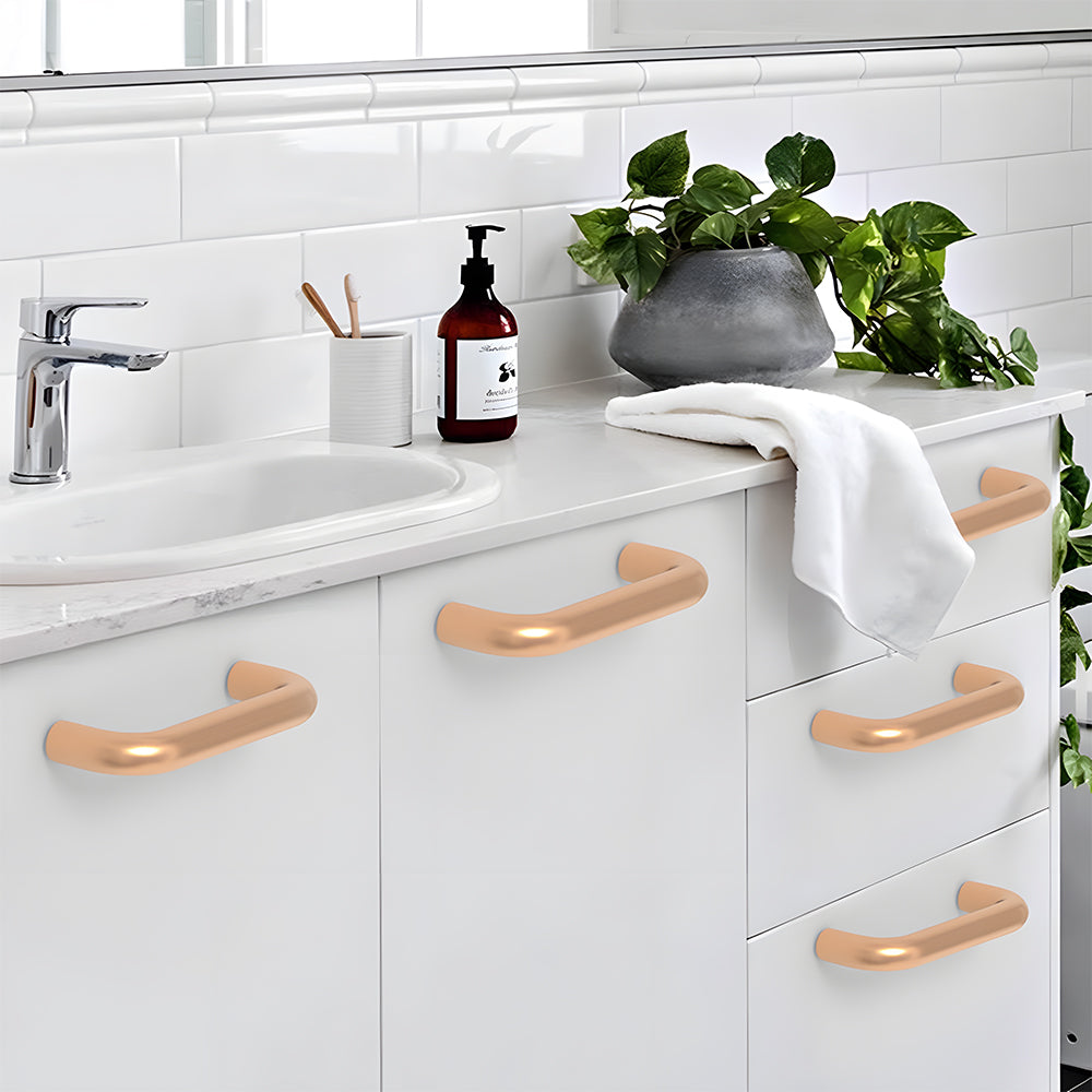 Champagne bronze rounded aluminum cabinet pull, shown clearly with its installed position visible