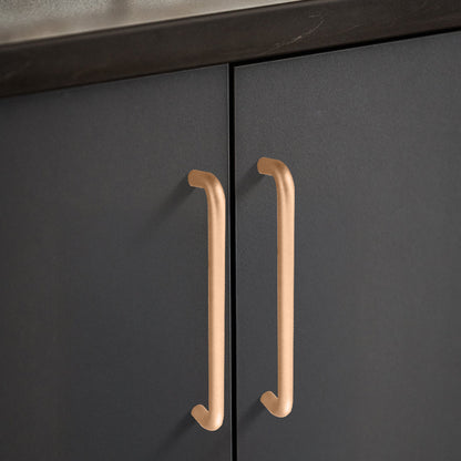 Champagne bronze rounded aluminum cabinet pull, pictured in one view with its installed position visible