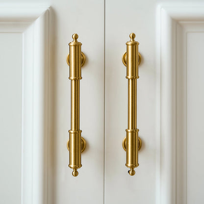 Antique brass round bar cabinet pull with matching T-knob, shown clearly in an installed cabinet close-up