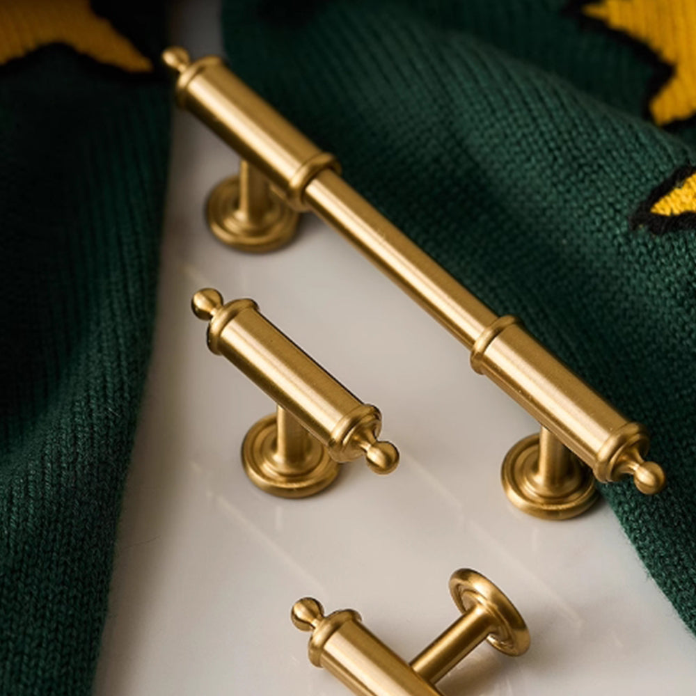 Antique brass round bar cabinet pull with matching T-knob, shown from one angle as a color and finish lineup