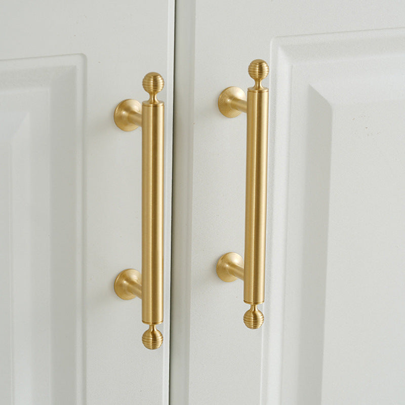 Antique bronze cabinet pull with matching ribbed knob, pictured in one view in an installed cabinet close-up