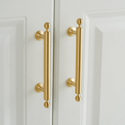 Antique bronze cabinet pull with matching ribbed knob, pictured in one view in an installed cabinet close-up