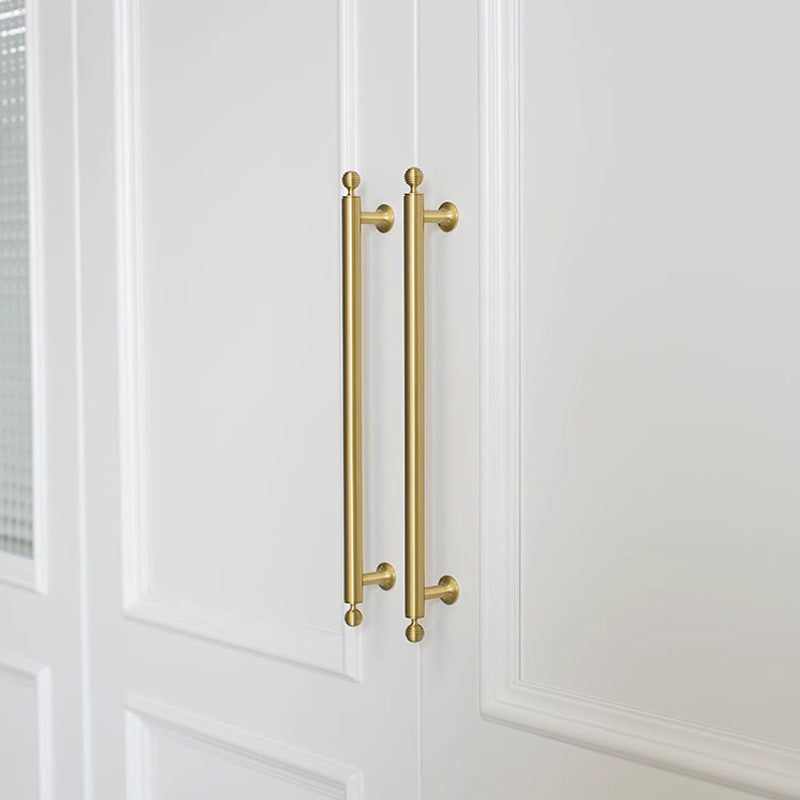 Antique bronze cabinet pull with matching ribbed knob, shown at close range in an installed cabinet close-up