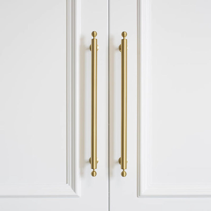 Antique bronze cabinet pull with matching ribbed knob, displayed from the side in an installed cabinet close-up