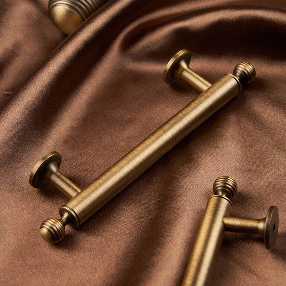 Antique bronze cabinet pull with matching ribbed knob, pictured in one view with its construction and finish visible