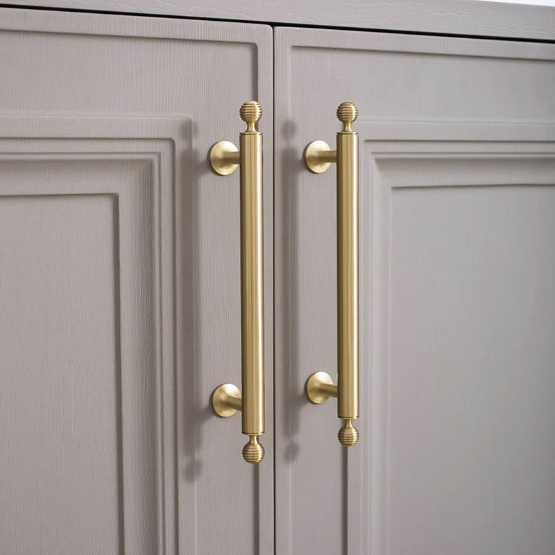 Antique bronze cabinet pull with matching ribbed knob, presented in another view in an installed cabinet close-up