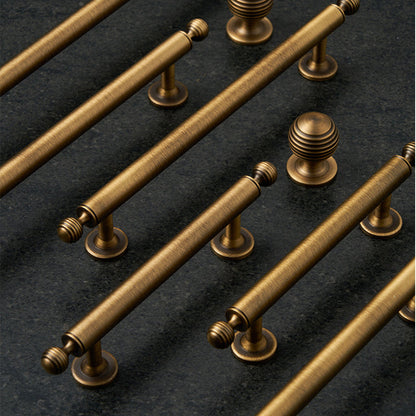 Antique bronze cabinet pull with matching ribbed knob, shown from one angle as a color and finish lineup