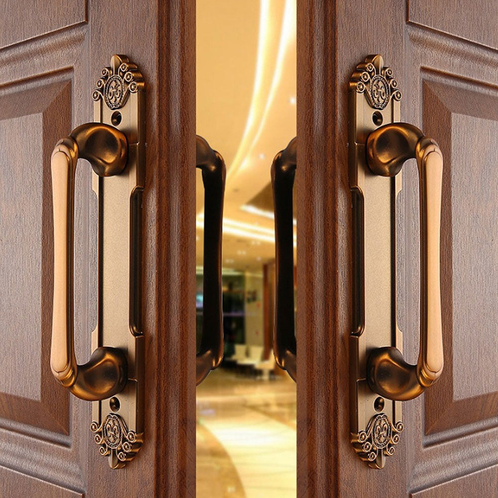 Antique bronze cabinet pull with decorative floral backplate, shown clearly in an installed cabinet close-up
