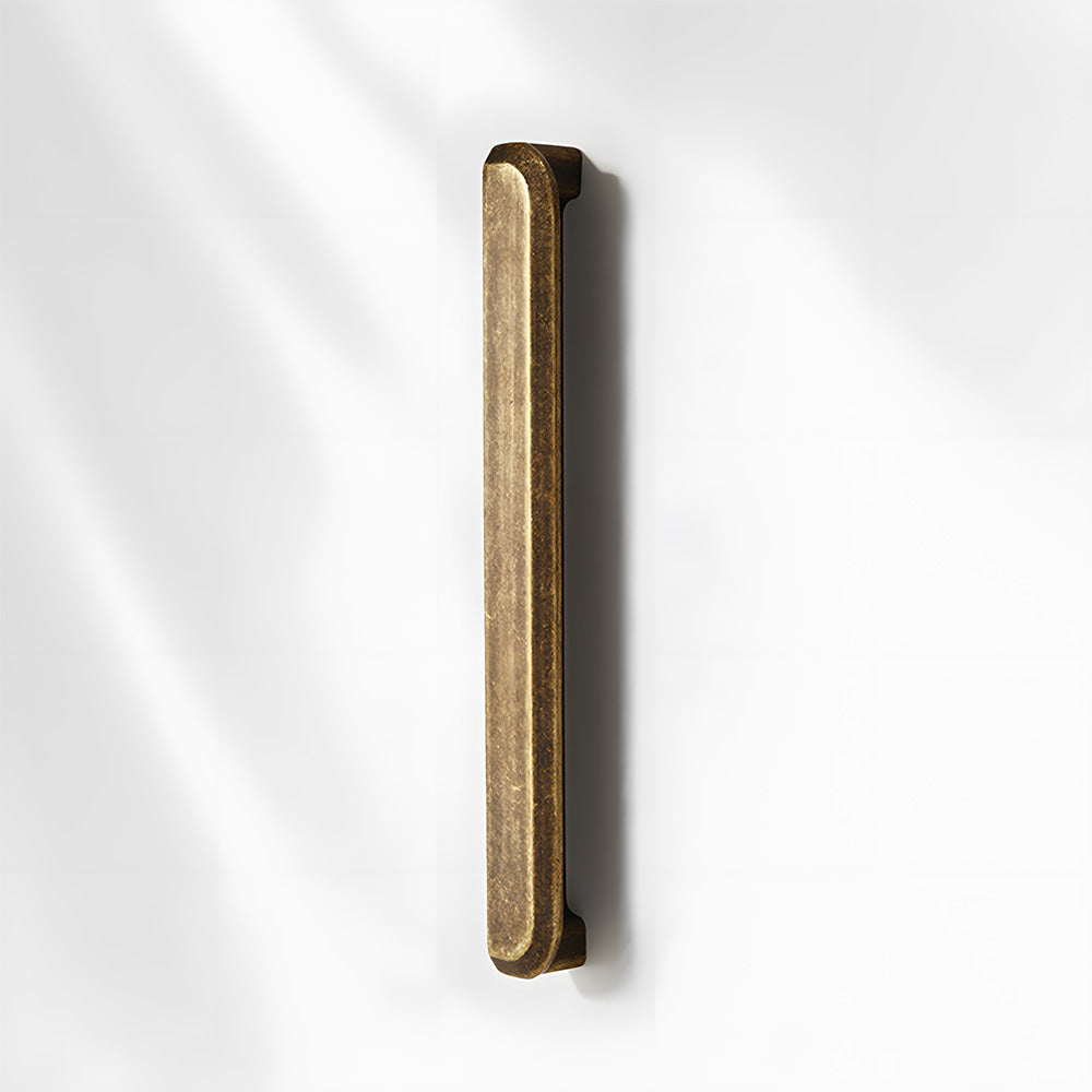 Antique bronze recessed cabinet pull, shown from one angle on a clean neutral background