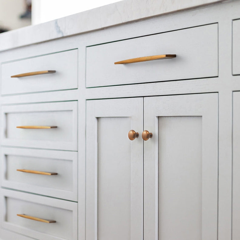 Arched aluminum cabinet pull, presented in another view installed on cabinetry in context