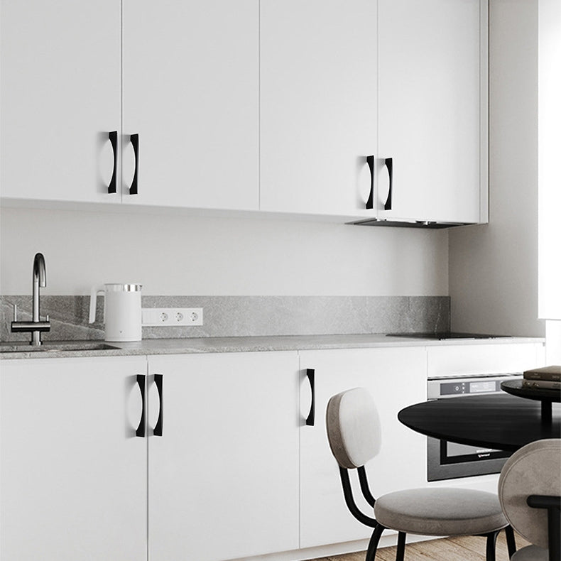 Black arched aluminum cabinet pull, shown clearly installed on cabinetry in context