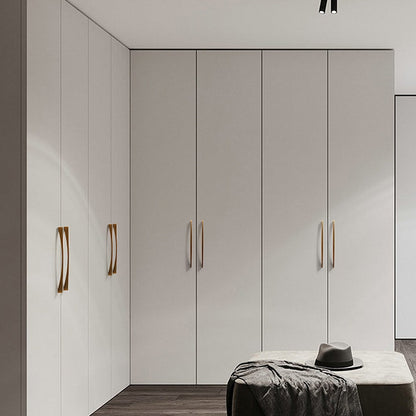 Arched aluminum cabinet pull, shown from one angle mounted on a finished cabinet front