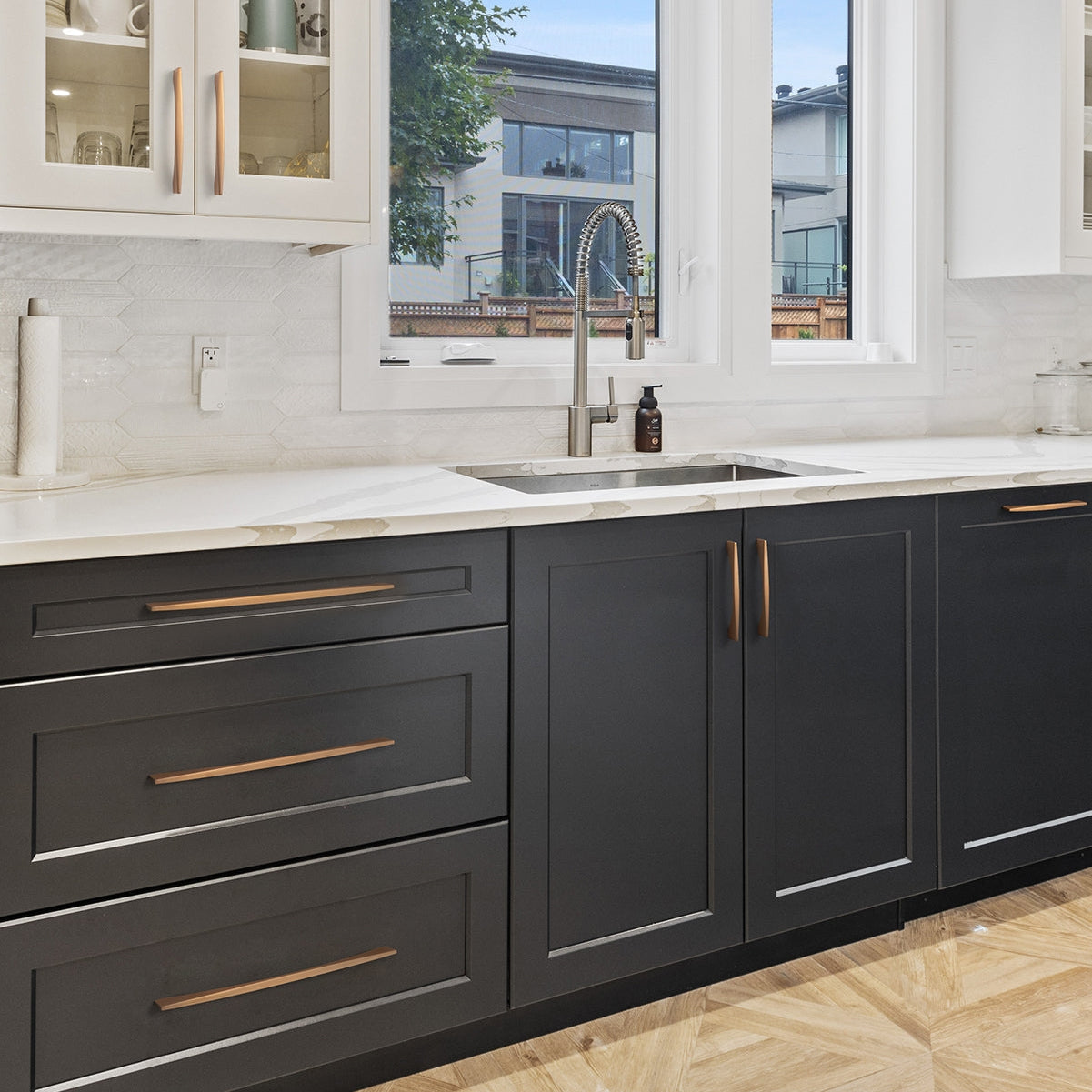 Arched aluminum cabinet pull, pictured in one view mounted on a finished cabinet front