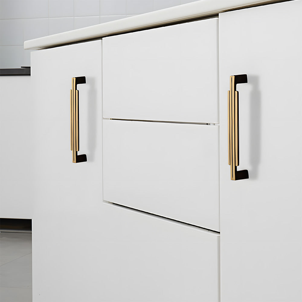 Art Deco brass cabinet pull and knob, pictured in one view installed on cabinetry in context