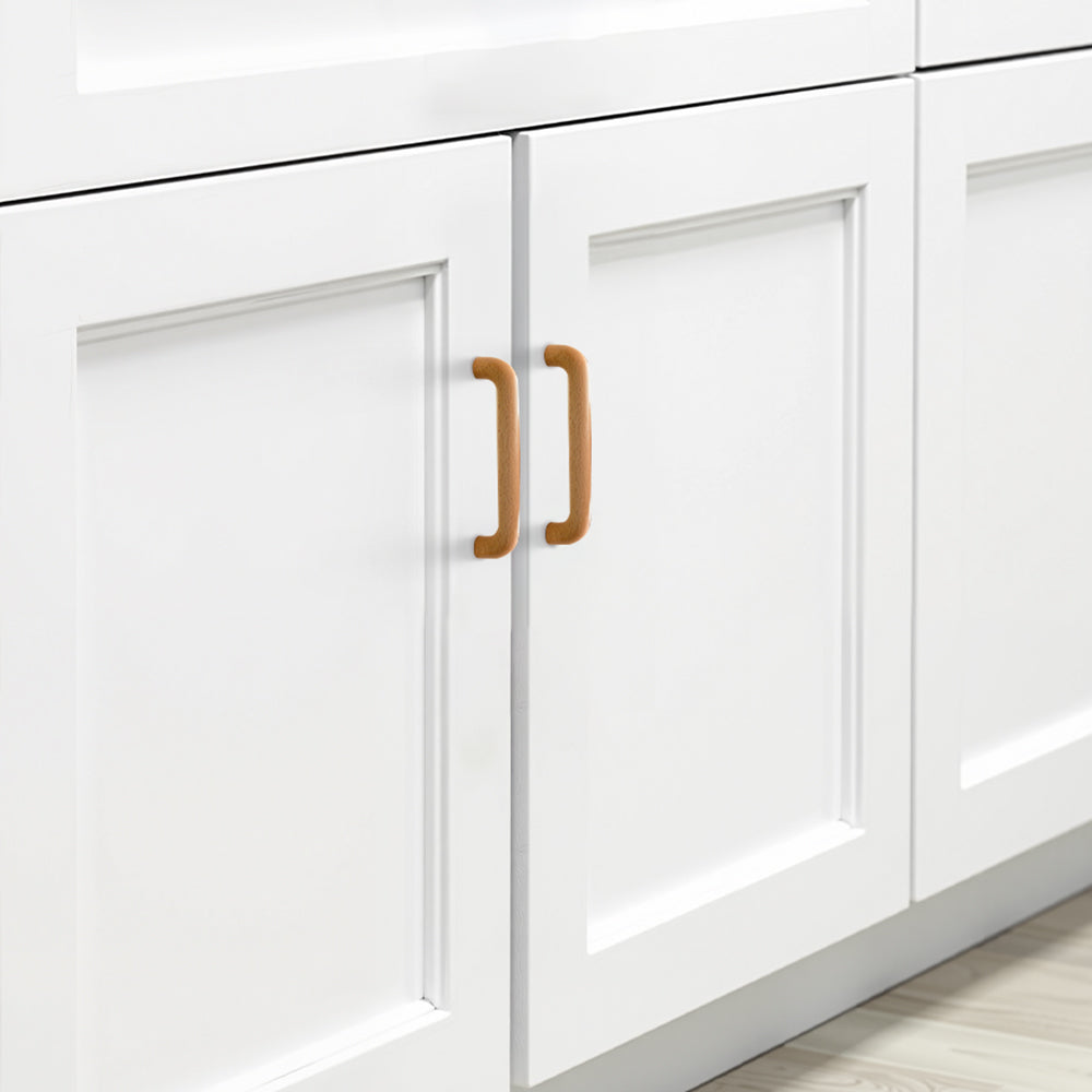 Beech wood cabinet pull in natural wood with 96 mm centers, installed on paired cabinet doors in a close view