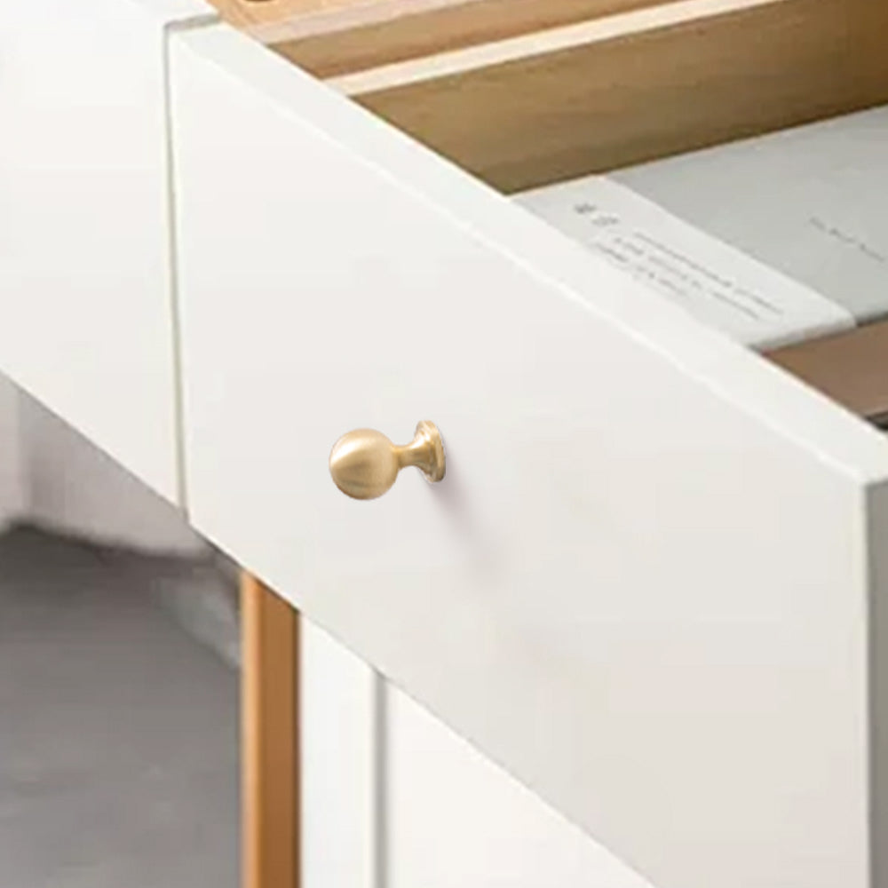 Gold brass round bar cabinet pull and round knob, presented for reference installed on cabinetry in context