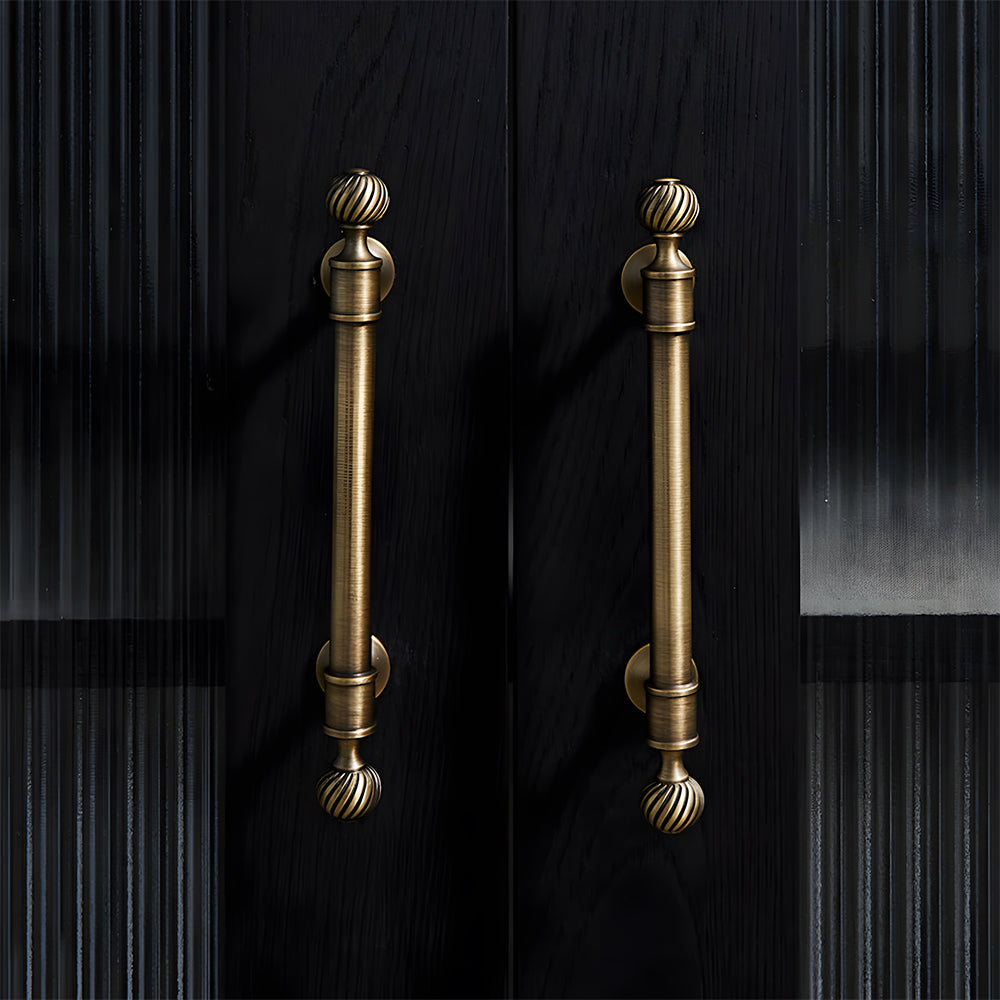Bronze ribbed brass cabinet pull and shell knob, shown clearly in an installed cabinet close-up
