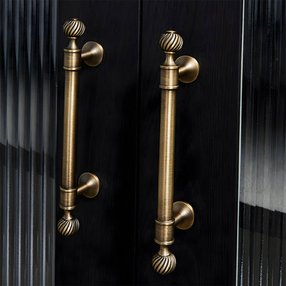 Bronze ribbed brass cabinet pull and shell knob, shown from one angle in an installed cabinet close-up