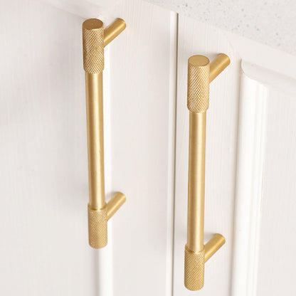 Knurled T-bar cabinet pull and round knob, shown from one angle in an installed cabinet close-up