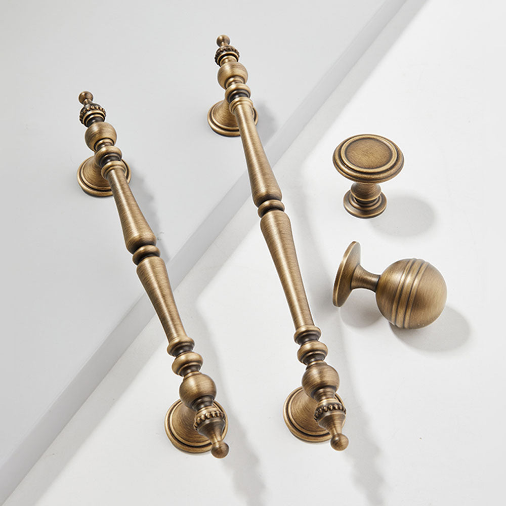 Ornate brass cabinet pull and knob, shown clearly as a color and finish lineup with key hardware details visible