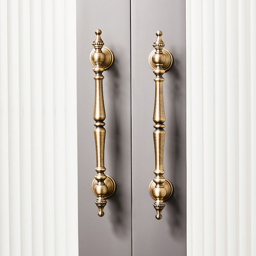 Bronze ornate brass cabinet pull and knob, shown from one angle in an installed cabinet close-up